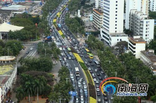 2014年2月5日，大年初六正值海南自驾旅客回程高峰，?？谛阌⒏酆湍细勐胪分土羟Я境蹬懦ち?。目前，港口及候船室秩序正常，旅客在站务人员和志愿者帮助下按班期分批登船。图为?？诟劭诼胪?，滞留的车辆排长队。(海报集团全媒体中心记者 张茂 摄)