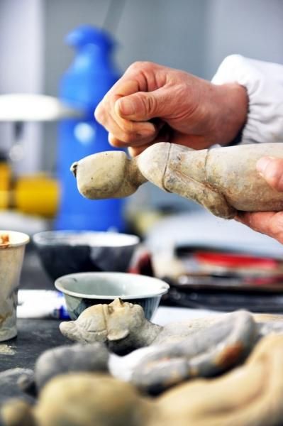 ▲上色好的文物进行做旧处理。