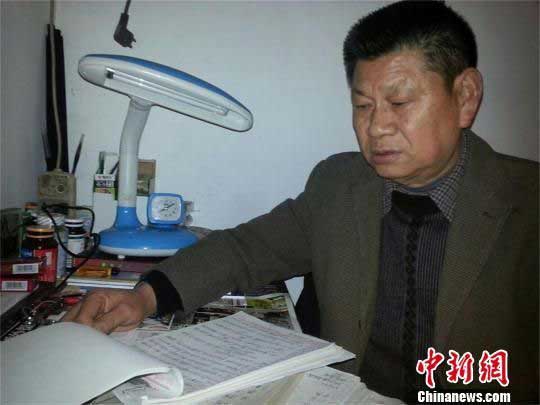 卢荣昌在翻看整理的笔记 马芙蓉 摄