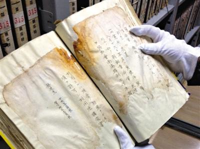 　4月30日，吉林省档案馆库房内，赵玉洁展示一册档案，库房内恒温恒湿，每天都会有例行的安全检查。新京报记者 卢美慧 摄