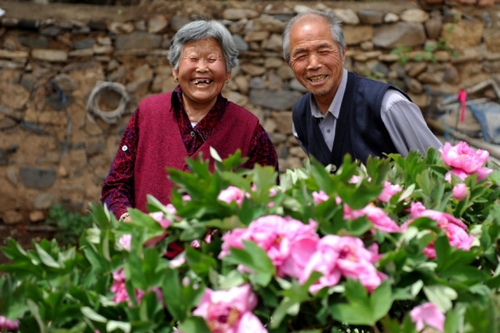 　5月13日，许润枕（右）和老伴儿董振贤在牡丹花前合影。