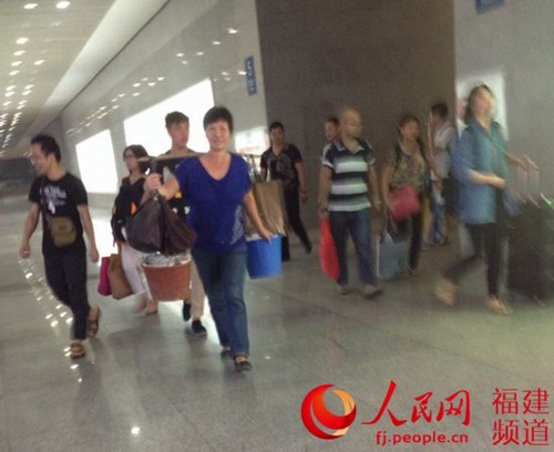 动车还没到站就自动醒来的她，又精神满满地挑着蛋走出厦门北站。林长生 摄