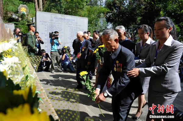 6月12日，参加公祭活动的老兵向中国远征军抗日将士纪念碑献花。当日，2014“中国远征军抗日阵亡将士”公祭活动在云南腾冲举行，从缅甸寻取的中国远征军抗日阵亡将士部分遗骸，归葬在腾冲国殇墓园中国远征军抗日阵亡将士墓。中新社发 刘冉阳 摄