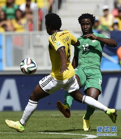 6月19日，科特迪瓦队球员维?博尼（右）与对方球员拼抢。当日，在巴西首都巴西利亚马内?加林查国家体育场进行的2014年巴西世界杯小组赛C组比赛中，哥伦比亚队对阵科特迪瓦队。 新华社记者戚恒摄