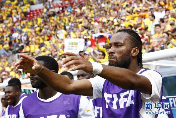 6月19日，未能首发上场的科特迪瓦队球员德罗巴（右）为场上队友加油助威。当日，在巴西首都巴西利亚马内?加林查国家体育场进行的2014年巴西世界杯小组赛C组比赛中，哥伦比亚队对阵科特迪瓦队。 新华社记者刘彬摄