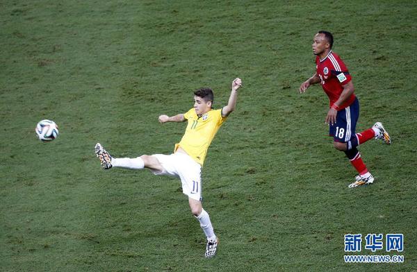 7月4日，巴西队球员奥斯卡（左）在比赛中。当日，在巴西福塔莱萨卡斯特洛竞技场进行的2014年巴西世界杯四分之一决赛中，巴西队对阵哥伦比亚队。 　　新华社记者廖宇杰摄
