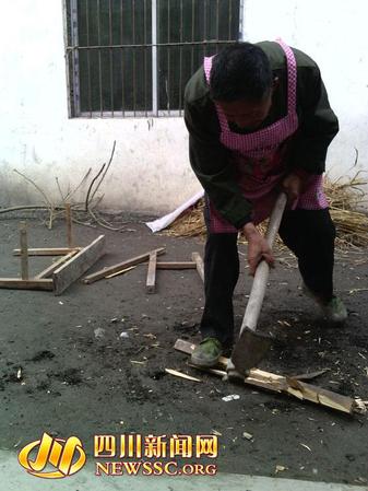老汉正在埋头将课桌劈来当柴烧 老汉正在埋头将课桌劈来当柴烧