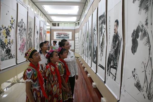 援疆捐赠暨书画创作展等系列文化公益活动在乌市举行。5图为少数民族学生认真观看书画展览