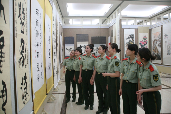 援疆捐赠暨书画创作展等系列文化公益活动在乌市举行。6图为部队战士在认真观看书画展览。