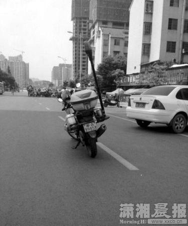 警务摩托车的车牌为“湘A9985警”，停放在主行驶道上。图片来自微博
