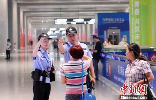 警察“夫妻档”热心解答旅客咨询。 侯启光 摄 警察“夫妻档”热心解答旅客咨询。 侯启光 摄