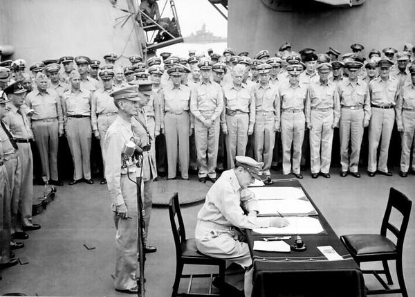 图为麦克阿瑟在受降书上签字。