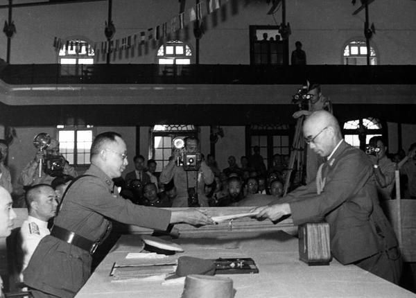 中国战区的日本投降仪式上，日本中国派遣军总司令官冈村宁次在对华投降书上签字，并向中方交出他的随身佩刀，以表示侵华日军正式向中国缴械投降。这是何应钦(左)在南京代表中国政府接受侵华日军总司令冈村宁次的投降书。