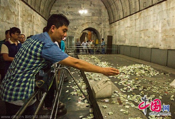 中国网8月15日讯 2014年8月14日，北京昌平区，5A级景区明十三陵定陵地宫内，历史文物上游客祈福所投过去的钱币堆成了小山，没有工作人员制止清理。