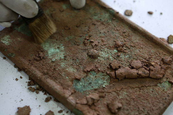 8月12日，工作人员在重庆市大足石刻研究院清理大足区城东的宋代墓葬群出土的铜镜。