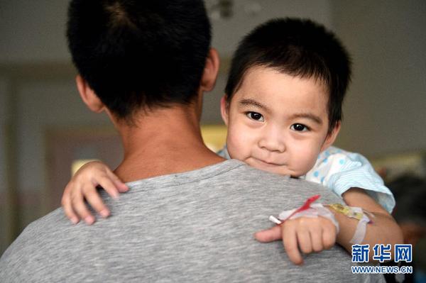 8月20日，在太原市山西省儿童医院病房内，“喂食爸爸”王志华抱着逐渐康复的小可然。