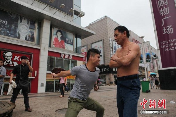 2014年08月18日，江西省南昌市，没有健硕的肌肉，却特别能承受拳力，48岁的湖北孝感男子谢水平不仅走遍全国各地向人发出挑战，甚至还把挨打当成了职业。昨天上午，谢水平来到八一广场说，三拳之内，能将他击退、双脚退到线后，就算挑战成功，单脚后退则是平局。