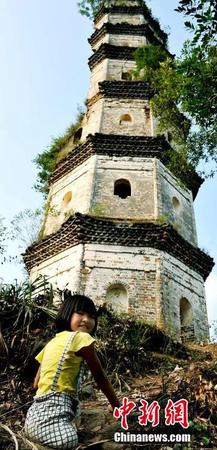 图为8月25日，“无腿女孩”蒋张子怡美丽的笑容与坚挺400多年的半边古塔相应成趣。卓忠伟 摄