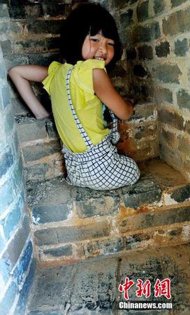 图为8月25日，“无腿女孩”蒋张子怡执意要自己亲手攀爬上塔。卓忠伟 摄1