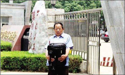 郑刚的父亲郑金龙抱着一包证据进法院 郑刚的父亲郑金龙抱着一包证据进法院