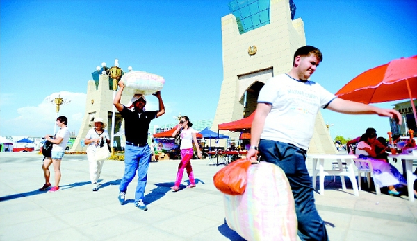 中哈霍尔果斯国际边境贸易区，中哈两边的生意堪称红火。哈萨克斯坦的游客购买中国的商品后，连提带扛地把货物运走。