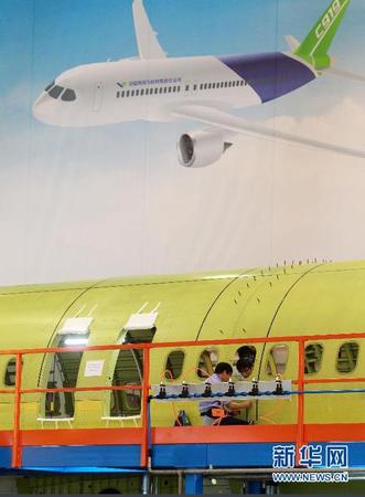 　 9月19日，技术人员对接C919首架机的机体。当日，C919国产大型客机首架机在中国商飞公司新落成的总装制造中心正式开始机体对接，这标志着C919大型客机研制项目全面进入结构总装攻坚阶段。项目力争年底完成首架机机体结构对接，2015年底实现首飞。新华社记者丁汀 摄