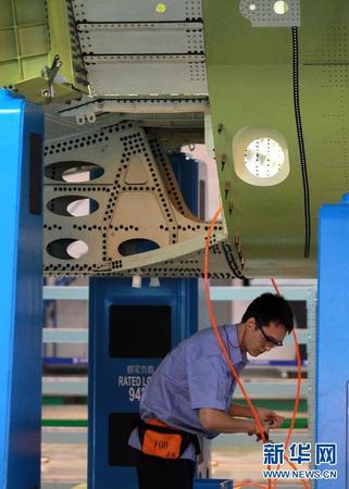 　 9月19日，技术人员在C919机体对合装配线上工作。当日，C919国产大型客机首架机在中国商飞公司新落成的总装制造中心正式开始机体对接，这标志着C919大型客机研制项目全面进入结构总装攻坚阶段。项目力争年底完成首架机机体结构对接，2015年底实现首飞。新华社记者裴鑫 摄