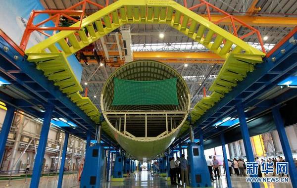这是在装配线上进行对接的C919首架机的机体（9月19日摄）。9月19日，C919国产大型客机首架机在中国商飞公司新落成的总装制造中心正式开始机体对接，这标志着C919大型客机研制项目全面进入结构总装攻坚阶段。项目力争年底完成首架机机体结构对接，2015年底实现首飞。新华社记者裴鑫 摄