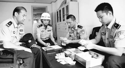 　8月6日晚上8点，司马义（左一）和督查组的同事清点爱心款。崔岱摄