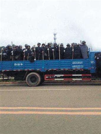 现场头戴钢盔手持木棍的人员。