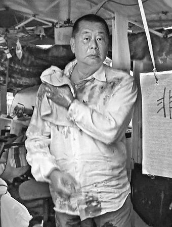 图片说明：黎智英12日被愤怒民众泼污物。