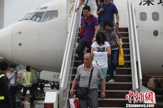 江苏警方将万某(白色上衣者)安全押解回国 江苏警方提供 摄 江苏警方将万某(白色上衣者)安全押解回国 江苏警方提供 摄