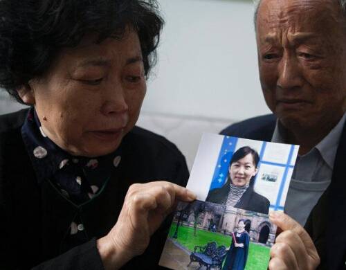 梁某父母捧着女儿照片痛不欲生 梁某父母捧着女儿照片痛不欲生