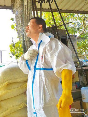 清洁队员闷在防疫衣里多时，中场休息卸下装备大口呼吸。《中国时报》
