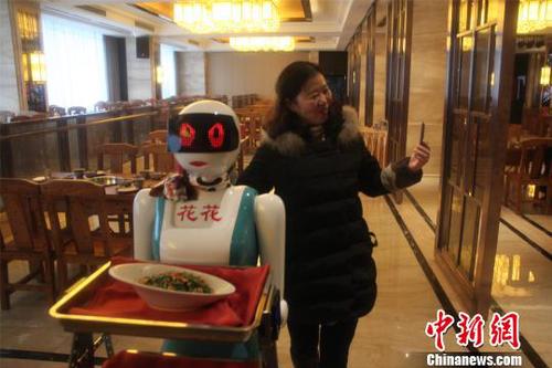 图为市民与机器人服务员拍照合影。　戴璐　摄