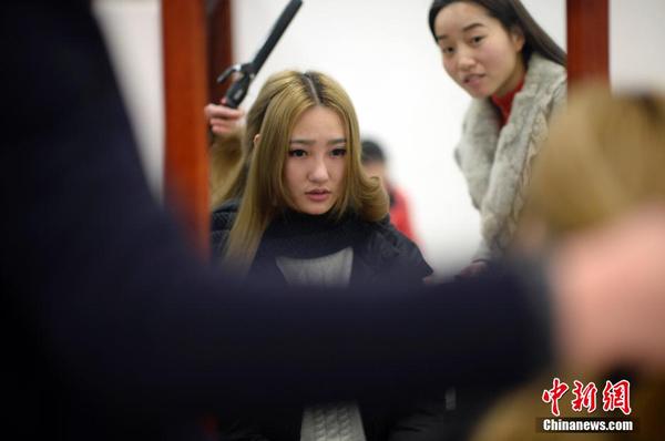 　图为黄宫梦玥用自带的化妆品化妆为登台做准备。中新社发 稻草 摄 图片来源：CNSPHOTO