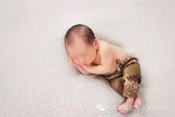 宝宝穿小号迷彩服拍照。