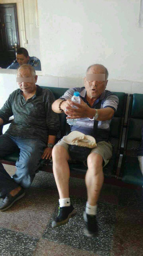 打人的两男子在派出所做笔录。