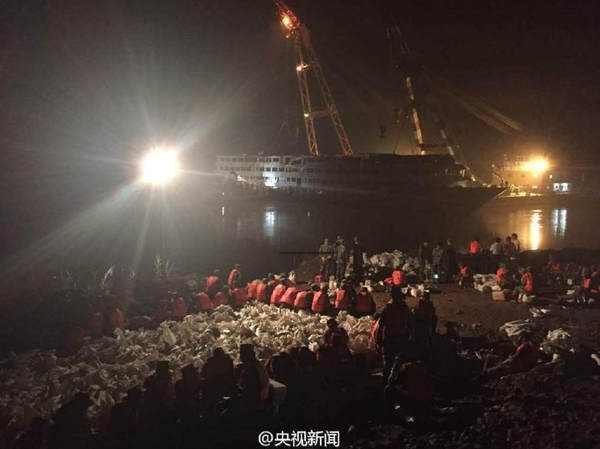 6月9日晚，打捞出水的“东方之星”发生一定程度倾斜，船体向左侧倾斜80厘米。武警官兵现场装沙袋配重调平，将沙袋运上东方之星右侧甲板放置，调平后将等待拖行至安全水域。据了解倾斜原因或与减载、水流等有关。央视记者刘峰 张宗尧 欧阳干湘 图片来源：央视新闻官方微博1