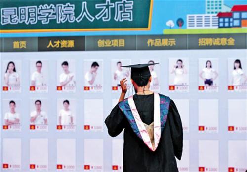 昨日，昆明学院一毕业生在人才店展板前驻足。当日，该校淘宝“昆明学院人才店”正式成立，65位毕业生亮相。新华社发