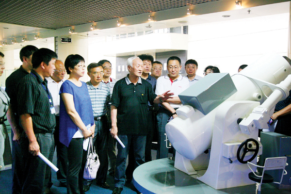 委员们实地了解电影经纬仪有关情况。    本报记者 高嵩 摄