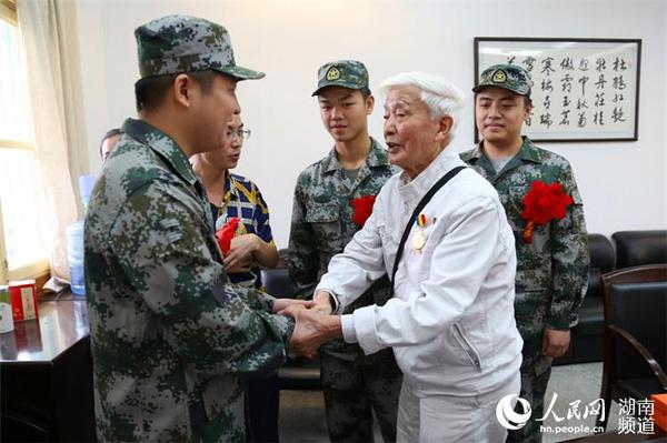 抗戰老兵方耀寰握住入伍新兵的手，囑咐他們要收好香港地區的繁榮與和平，在軍隊努力學習，為國貢獻。 胡丹  攝