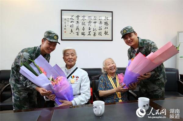 岳麓區即將去往駐港部隊的新兵代表為抗戰老兵方耀寰、惲順芳送上鮮花與月餅，祝福老人節日快樂。 胡丹 攝