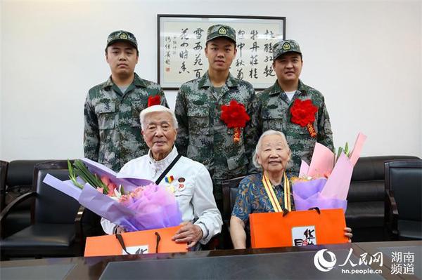 9月8日，岳麓區即將去往駐港部隊的新兵代表為抗戰老兵方耀寰、惲順芳送上鮮花與月餅，祝福老人節日快樂。 胡丹 攝