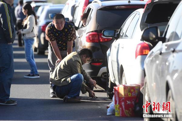 10月1日，十一黄金周第一天，受出京自驾游玩车辆增多影响，京沪高速泗村店路段严重拥堵。图为一位司机正在换轮胎。小可 摄 图片来源 CFP视觉中国