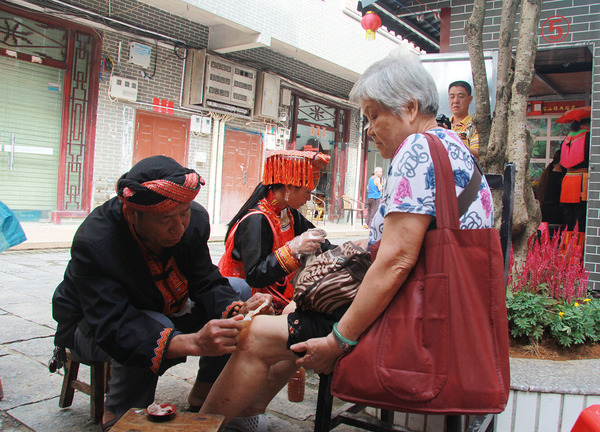 群众在金秀县瑶医药一条街接受瑶医治疗