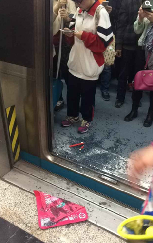 地铁到站后，网友拍摄的被砸车门的玻璃渣