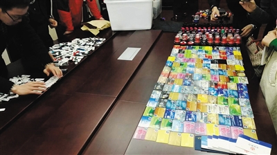 　10月30日，兰溪县公安局，浙江金华“9·16”专案组民警展示大量的银行卡、公章及U盾等地下钱庄作案工具。 警方供图