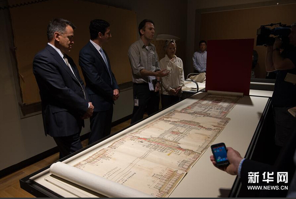 12月8日，在位于澳大利亚堪培拉的澳大利亚国家图书馆展厅，策展人内森·沃利博士（左三）向媒体介绍中国国家图书馆出借的展品——《大清门至坤宁宫中一路立样糙底》。