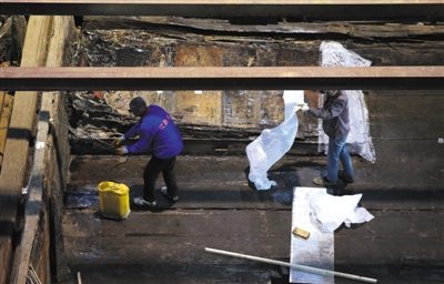 15日，南昌?；韬钅?，考古工作人员给大墓主棺（图左上角）盖上保护层。新京报记者 薛珺 摄